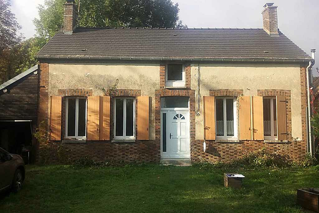 Façade d'une maison ancienne avant travaux, enduits ciment décollés et joints dégradés