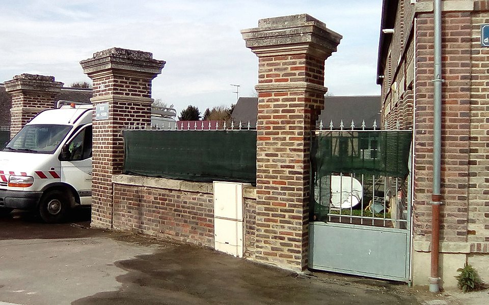 Piliers de portail en briques rouges reconstruits après un choc de véhicule