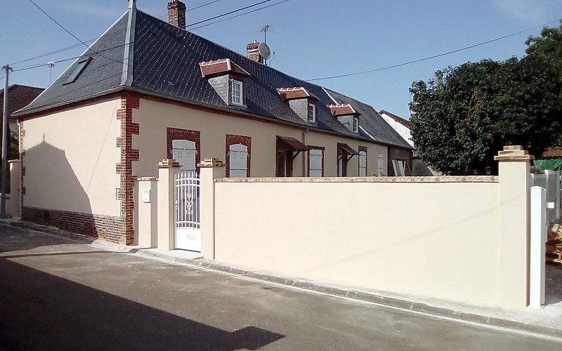 Maison de village dont la façade et le mur de clôture viennent d'être ravalés